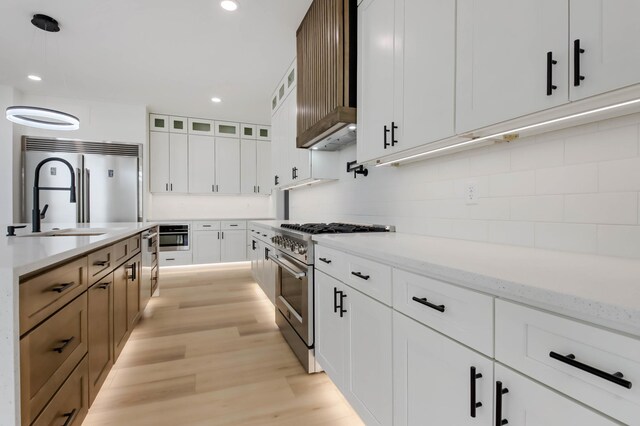 1796 Cobblestone Ct, Hastings, MN 55033 - kitchen featuring premium appliances, decorative backsplash, light wood finished floors, decorative light fixtures, and recessed lighting