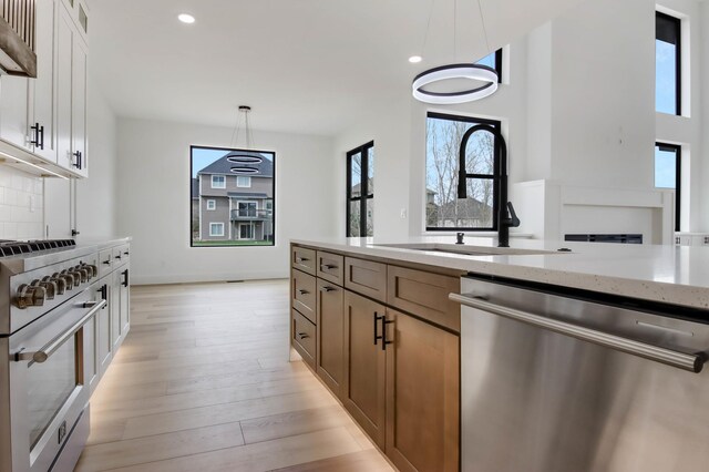 1796 Cobblestone Ct, Hastings, MN 55033 - kitchen featuring stainless steel appliances, a sink, light stone countertops, healthy amount of natural light, and recessed lighting