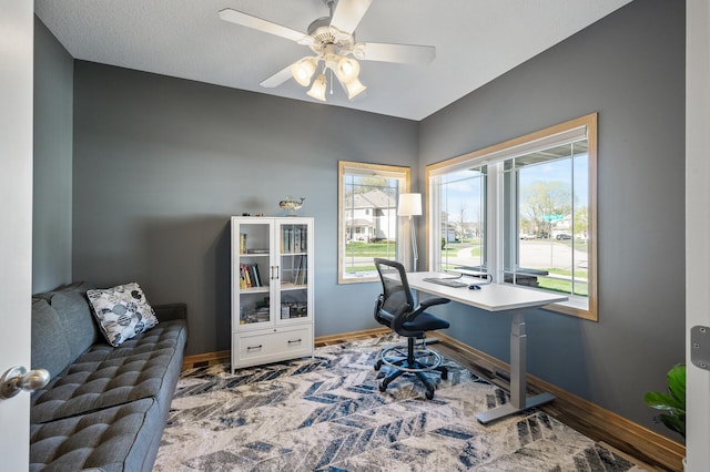 office area with baseboards and a ceiling fan