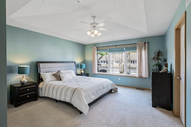 bedroom with carpet, a textured ceiling, baseboards, and ceiling fan