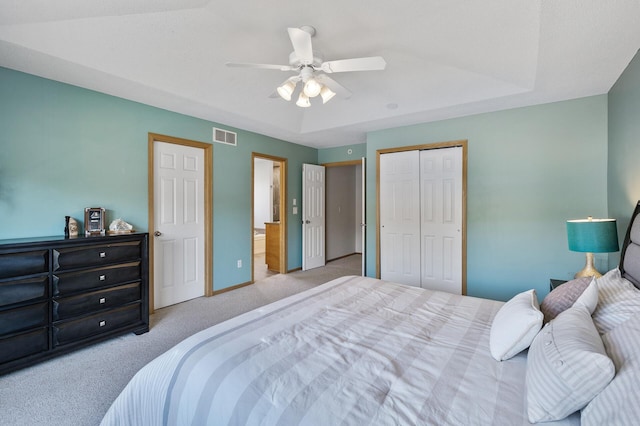 bedroom with carpet, a closet, a ceiling fan, ensuite bath, and baseboards