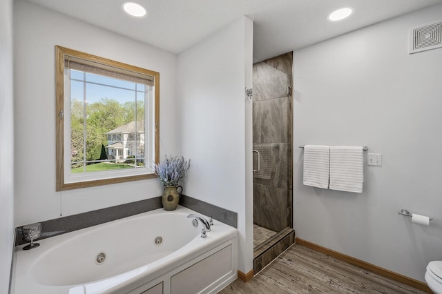 full bathroom featuring a shower stall, a tub with jets, wood finished floors, toilet, and recessed lighting