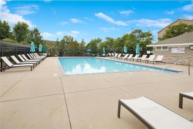 community pool featuring a patio and fence
