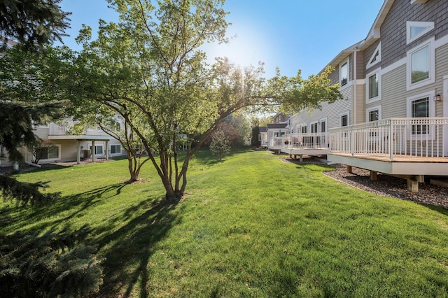 view of green lawn featuring a wooden deck