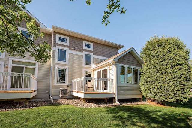 rear view of house featuring a deck and a yard