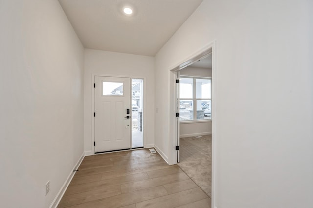 foyer entrance featuring light wood finished floors and baseboards
