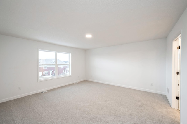 empty room with light carpet, baseboards, and recessed lighting