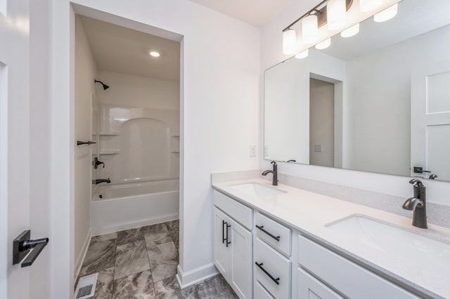 bathroom featuring a sink, double vanity, baseboards, and marble finish floor