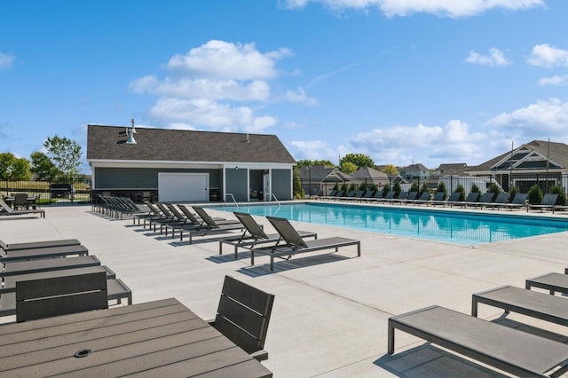 pool featuring fence and a patio area