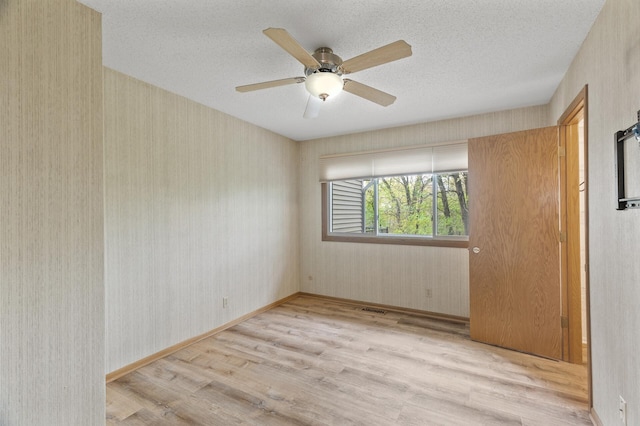 4348 Arden View Ct, Arden Hills, MN 55112 - unfurnished room featuring wood finished floors, a ceiling fan, a textured ceiling, and wallpapered walls