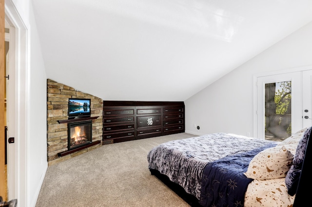 bedroom featuring lofted ceiling, carpet floors, and a fireplace