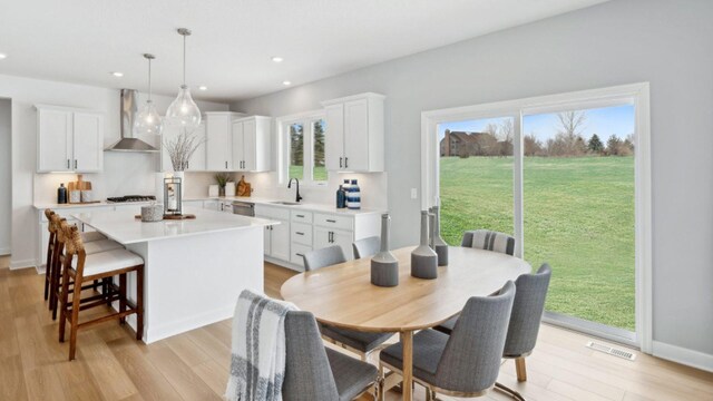 dining space with recessed lighting, light wood-style flooring, and healthy amount of natural light