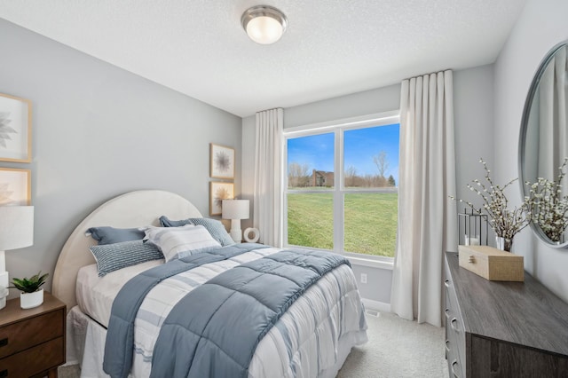 bedroom with baseboards, light carpet, and a textured ceiling