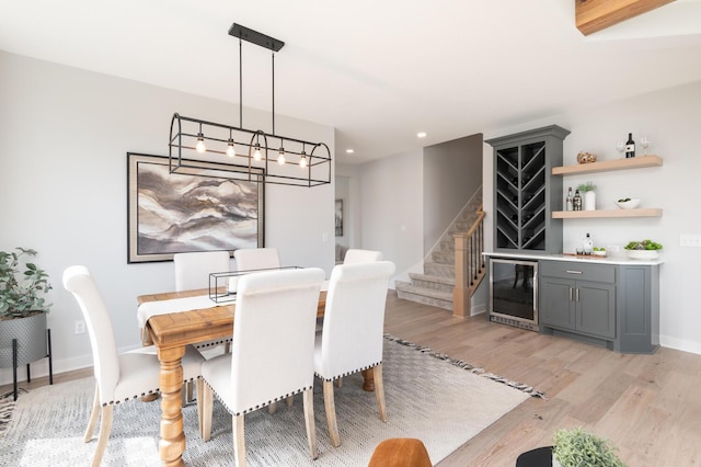 dining area featuring wine cooler, a dry bar, light wood-type flooring, stairway, and recessed lighting