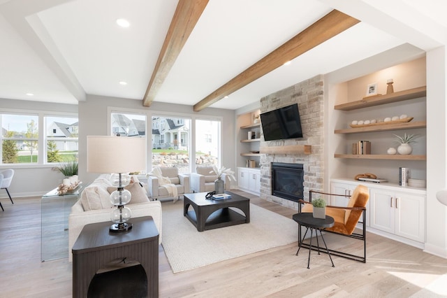 living area featuring a fireplace, light wood-type flooring, baseboards, beamed ceiling, and built in shelves