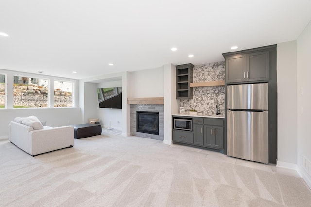 living room featuring light colored carpet, recessed lighting, baseboards, and a tile fireplace