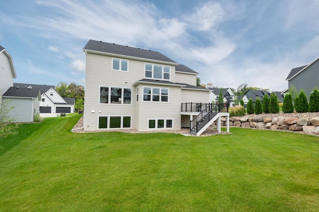 rear view of house featuring stairs, a deck, a lawn, and a residential view