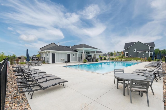 community pool with fence and a patio area