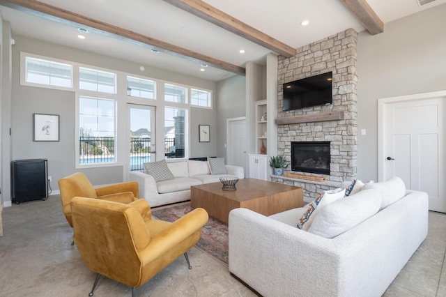 living area with a fireplace, beam ceiling, a high ceiling, built in shelves, and recessed lighting