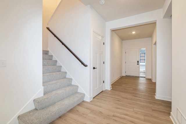 entrance foyer featuring light wood-type flooring, stairs, baseboards, and recessed lighting