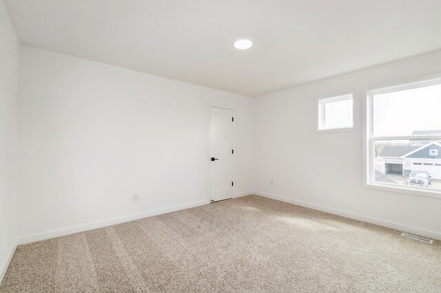 empty room featuring carpet and baseboards