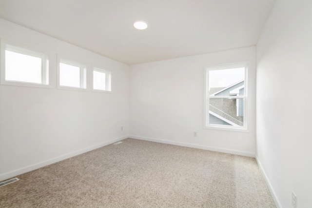 spare room with light carpet and baseboards
