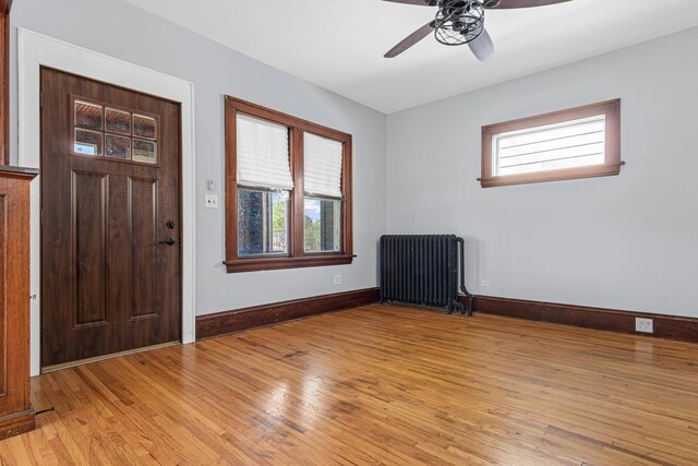 604 Asbury St, Saint Paul, MN 55104 - foyer with radiator, a ceiling fan, light wood-style flooring, and baseboards