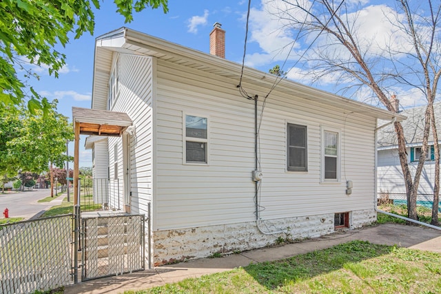 604 Asbury St, Saint Paul, MN 55104 - view of property exterior featuring fence, a chimney, and a gate