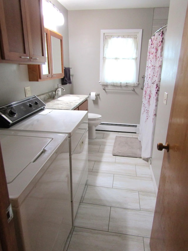 318 3rd St, Dawson, MN 56232 - full bathroom with washing machine and clothes dryer, a baseboard heating unit, vanity, toilet, and baseboards