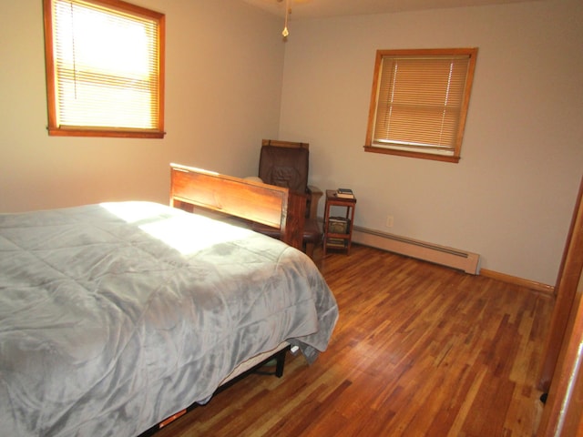 318 3rd St, Dawson, MN 56232 - bedroom with baseboard heating, wood finished floors, and baseboards