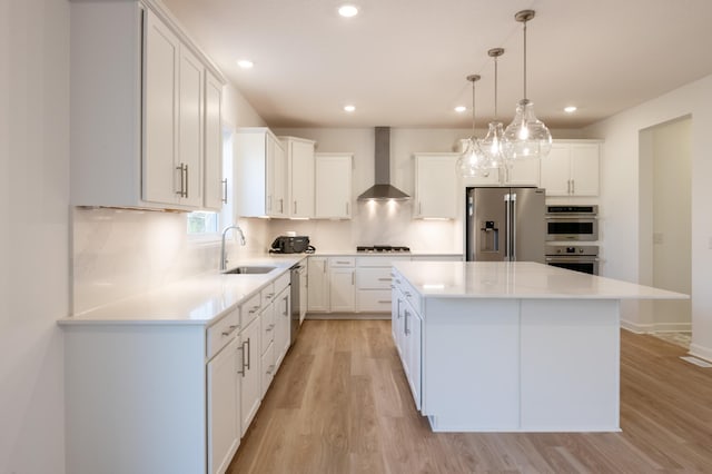 15710 112th Ave N, Dayton, MN 55369 - kitchen with wall chimney range hood, stainless steel appliances, a sink, light wood finished floors, and a kitchen island