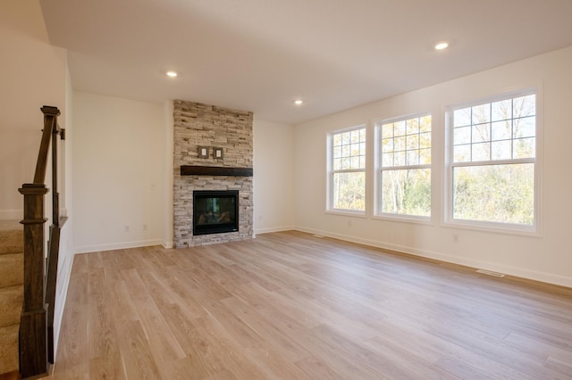 15710 112th Ave N, Dayton, MN 55369 - unfurnished living room featuring light wood finished floors, stairs, baseboards, recessed lighting, and a stone fireplace