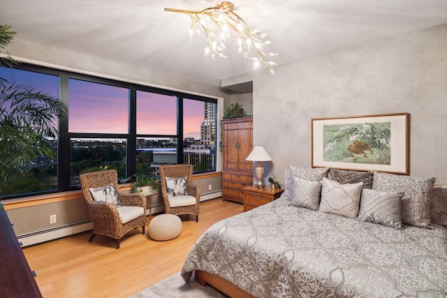 215 10th Ave S Unit 812, Minneapolis, MN 55415 - bedroom featuring a baseboard heating unit, wood finished floors, and a chandelier
