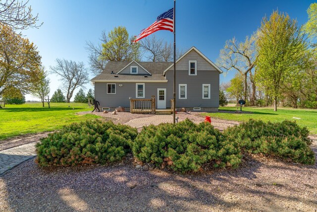 rear view of property with a wooden deck and a lawn