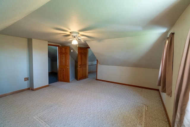 bonus room featuring light colored carpet, ceiling fan, lofted ceiling, and baseboards