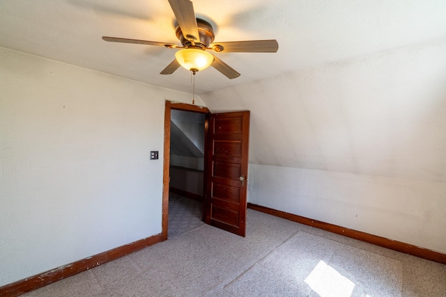 carpeted spare room with a ceiling fan and baseboards