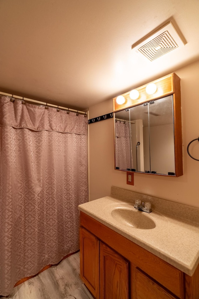 full bath with wood finished floors and vanity