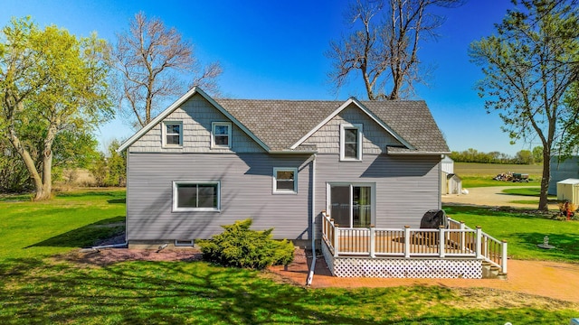 rear view of house with a deck and a yard