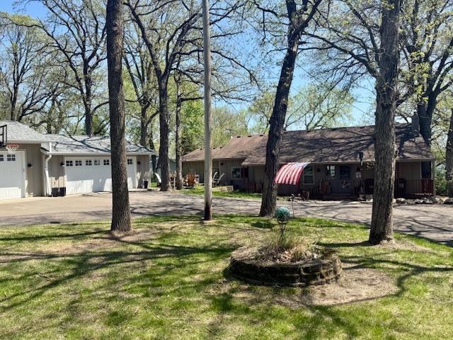 view of front facade with an attached garage, asphalt driveway, and a front lawn