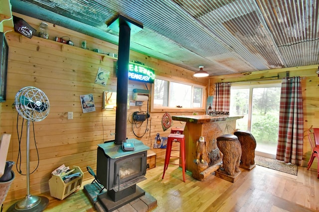 5151 99th Ave, Clear Lake, MN 55319 - bar featuring a wood stove, wooden walls, and wood-type flooring