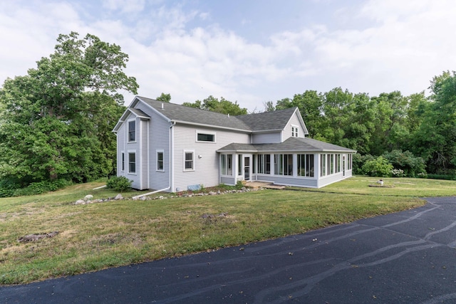 15126 Tumuli Rd, Dalton, MN 56324 - view of front of house with a sunroom, roof with shingles, and a front lawn