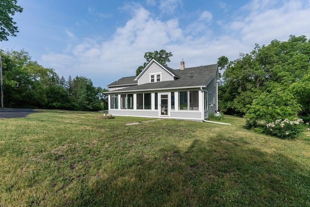 15126 Tumuli Rd, Dalton, MN 56324 - rear view of property featuring a chimney, a sunroom, a yard, and a shingled roof