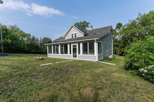 15126 Tumuli Rd, Dalton, MN 56324 - back of house featuring a sunroom, a yard, a chimney, and roof with shingles
