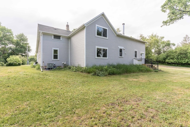 15126 Tumuli Rd, Dalton, MN 56324 - back of house with a lawn, a chimney, and central air condition unit