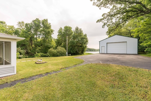15126 Tumuli Rd, Dalton, MN 56324 - view of grassy yard featuring a garage, an outbuilding, and driveway