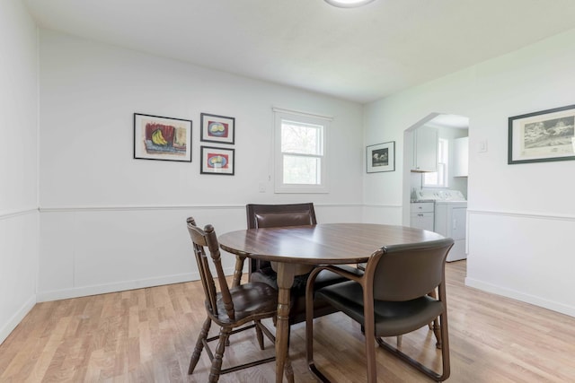 15126 Tumuli Rd, Dalton, MN 56324 - dining space with washer and clothes dryer, light wood-type flooring, arched walkways, and baseboards