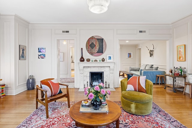 421 Summit Ave Unit 2, Saint Paul, MN 55102 - living room featuring a decorative wall, light wood finished floors, crown molding, and a fireplace