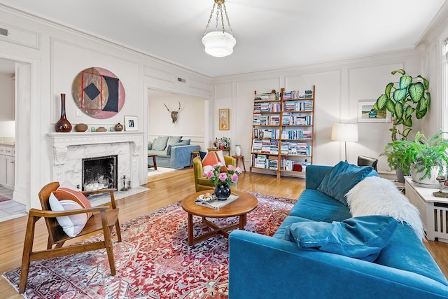 421 Summit Ave Unit 2, Saint Paul, MN 55102 - living area featuring a decorative wall, crown molding, wood finished floors, and a premium fireplace