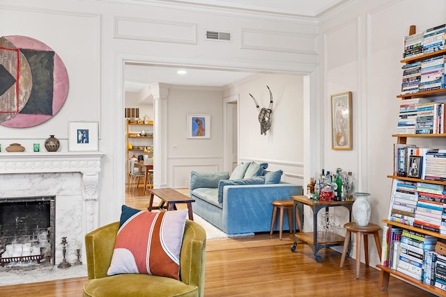 421 Summit Ave Unit 2, Saint Paul, MN 55102 - living area with ornamental molding, a decorative wall, a premium fireplace, wood finished floors, and ornate columns