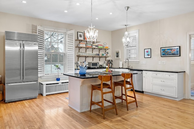 421 Summit Ave Unit 2, Saint Paul, MN 55102 - kitchen with appliances with stainless steel finishes, radiator heating unit, a chandelier, recessed lighting, and light wood finished floors